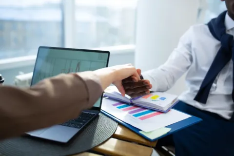 Tumpukan berkas dokumen cara membuat proposal bisnis di atas meja ruang rapat kerja