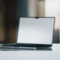Seseorang sedang bekerja menggunakan gadget laptop dan smartphone di meja kerja modern