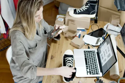 Pemilik usaha sedang mengemas barang dagangan untuk mengirim pesanan dari cara mengembangkan bisnis online