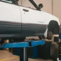 Mekanik sedang melakukan cara merawat mobil agar selalu prima di bengkel