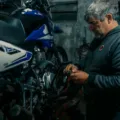 Mekanik sedang melakukan cara merawat motor agar performa mesin tetap maksimal