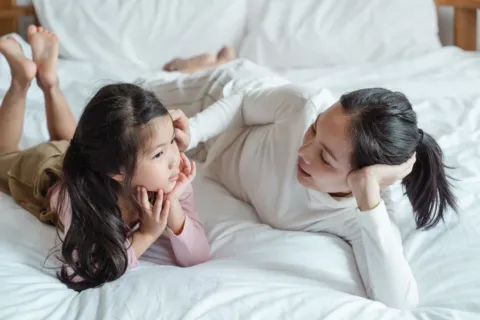 Orang tua sedang menerapkan komunikasi positif dengan anak di rumah yang hangat