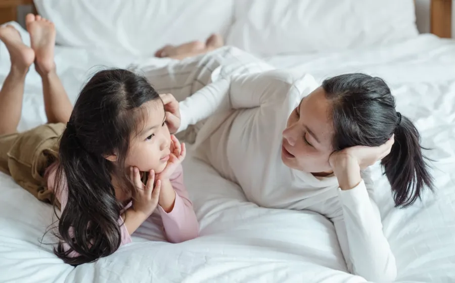 Orang tua sedang menerapkan komunikasi positif dengan anak di rumah yang hangat