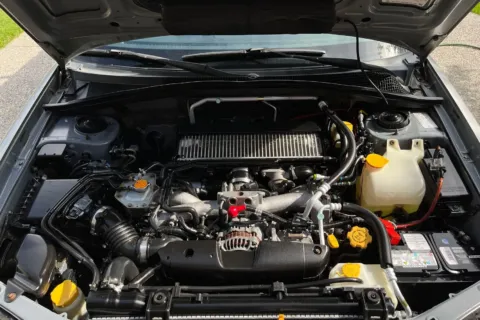Ilustrasi mekanik sedang melakukan pengecekan mesin untuk mempraktikkan tips merawat mobil agar tetap prima