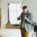 Fotografer profesional sedang memotret dengan kamera mirrorless dalam proses membangun usaha jasa fotografi