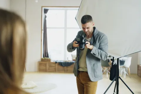 Fotografer profesional sedang memotret dengan kamera mirrorless dalam proses membangun usaha jasa fotografi