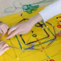 Anak kecil belajar menata balok kayu sebagai cara membantu anak mengembangkan kemampuan motorik di rumah