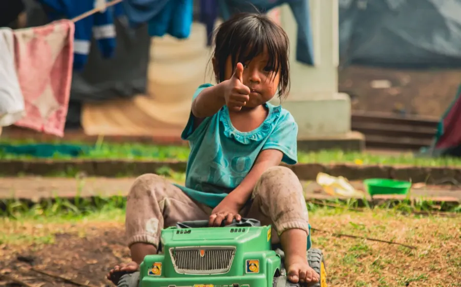 Seorang anak perempuan tersenyum percaya diri saat bermain menyusun balok kayu di rumah