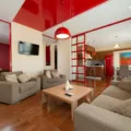 Penataan furnitur rumah yang sesuai dengan sofa minimalis dan meja kayu fungsional di ruang tamu lapang
