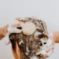 Seseorang sedang mencuci rambut di kamar mandi sebagai cara mengatasi kulit kepala berminyak yang lepek