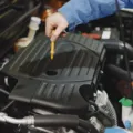 Cara merawat mobil secara rutin dengan memeriksa level oli mesin menggunakan dipstik