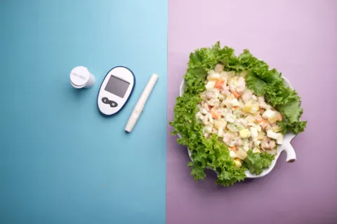 Seseorang sedang menyiapkan makanan sehat berprotein dan sayuran untuk menjaga kadar gula darah stabil