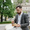 Pekerja kantor memperagakan tips menjaga kebugaran tubuh dengan merenggangkan tangan di sela jam kerja
