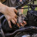 Mekanik sedang mempraktikkan tips merawat motor secara rutin di bengkel