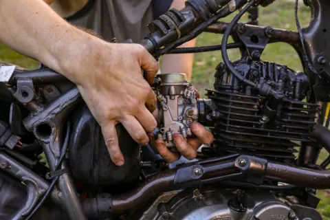 Mekanik sedang mempraktikkan tips merawat motor secara rutin di bengkel
